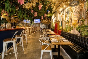 Een restaurantinterieur met een lange toonbank, meerdere tafels en een bar.