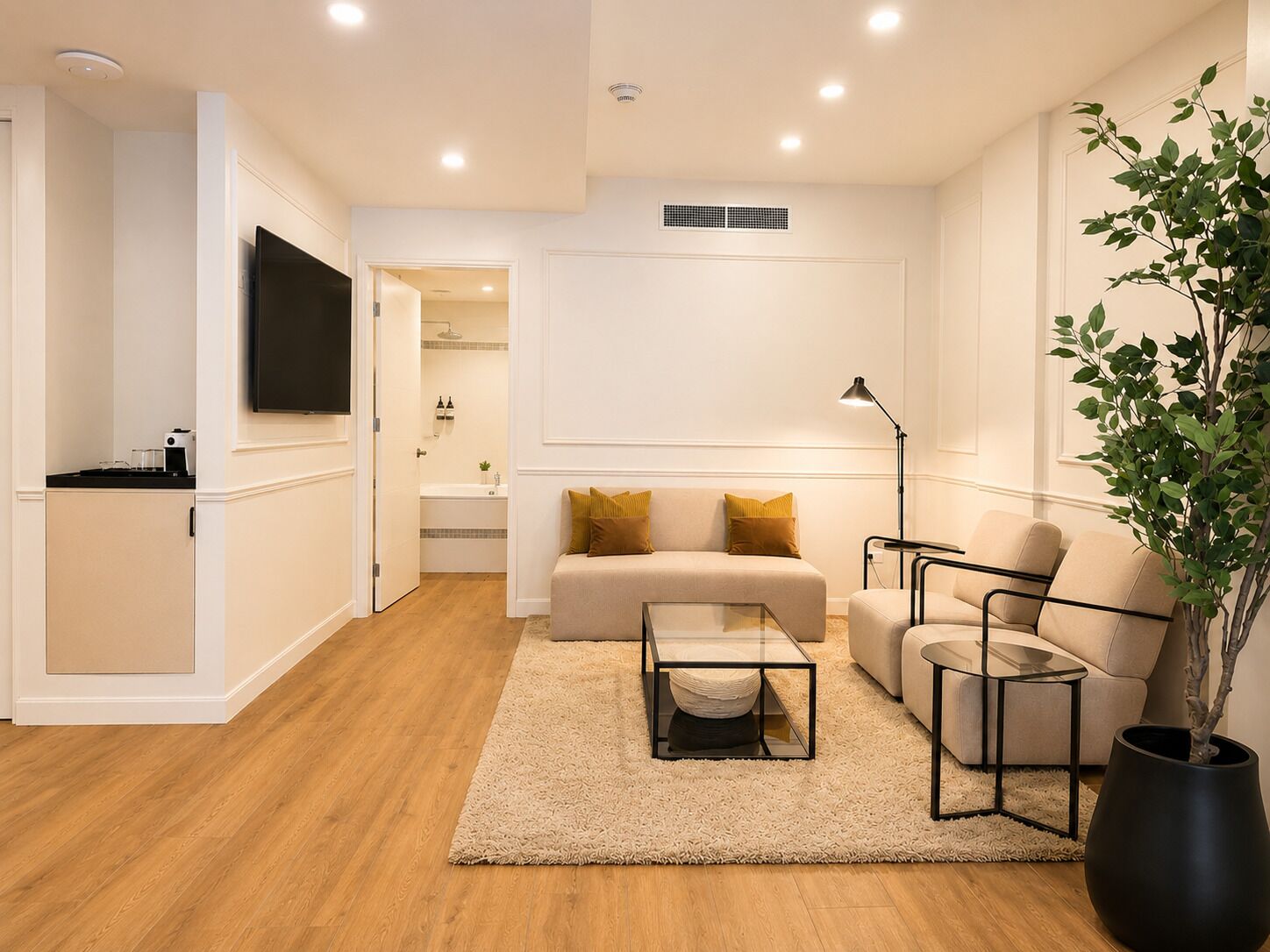 A modern living room with a sofa, armchairs, a coffee table, and a TV.