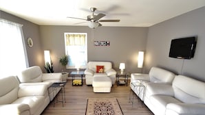 A spacious living room with two white sofas, a coffee table, a rug, and a ceiling fan. - Private Retreat Bungalow-One Level, 2 blocks from Beach w/Porch & Deck (Colonial Beach)