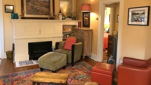 A cozy living room with a fireplace, comfortable seating, and a colorful rug. - Cheerful 3 Bdrm w/ Kitchen & LR in West Seattle (Seattle)