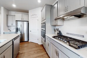 Prepare meals in the fully equipped kitchen with a refrigerator, oven, and stove.
