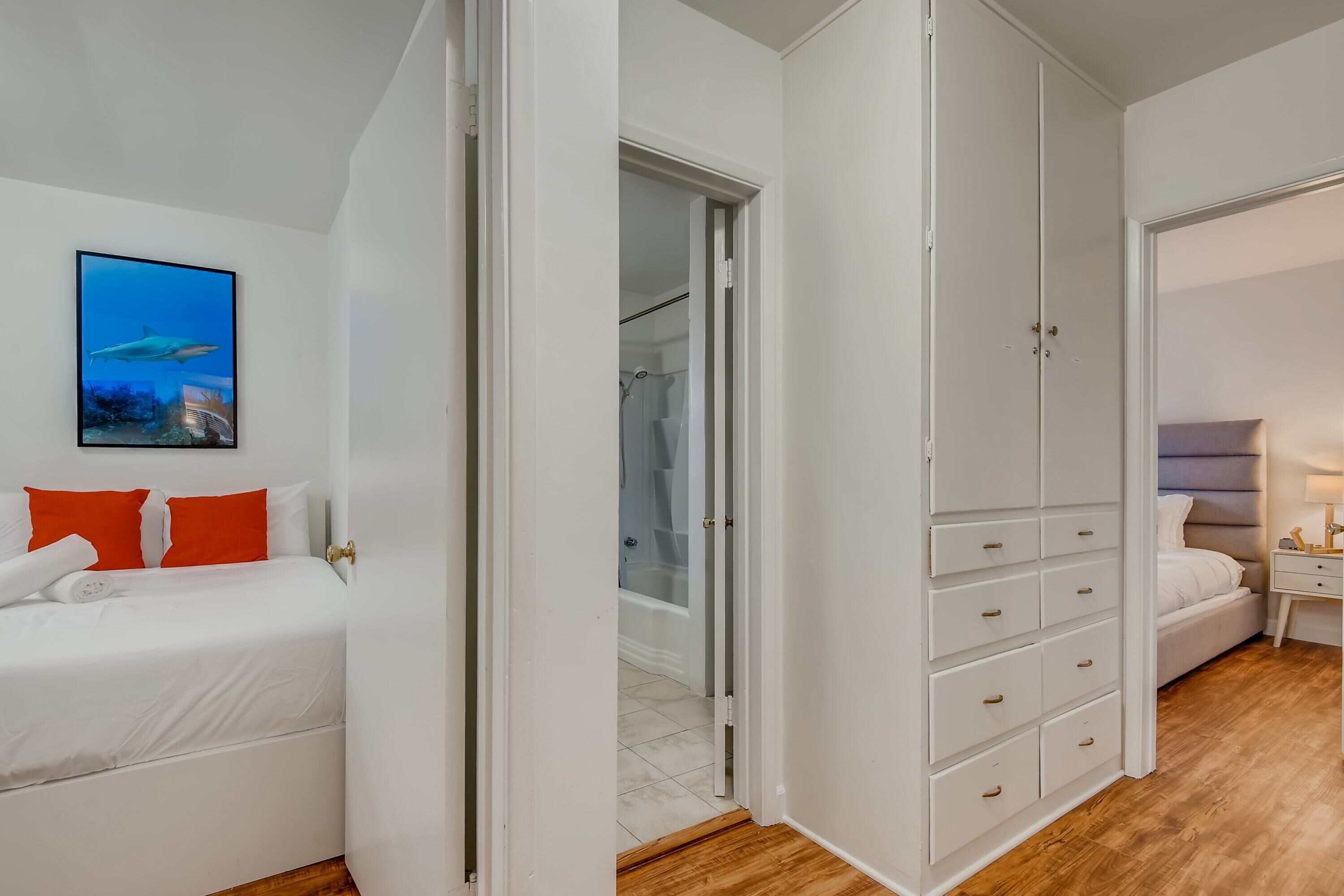 A bedroom with a bed, a wardrobe, and a bathroom visible through an open door.