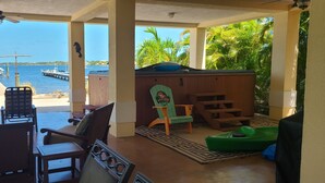 Un espacio de estar al aire libre cubierto con vistas al agua y barcos amarrados.