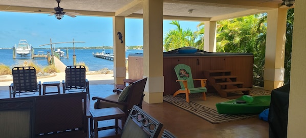A covered outdoor seating area with a view of the water and docked boats.