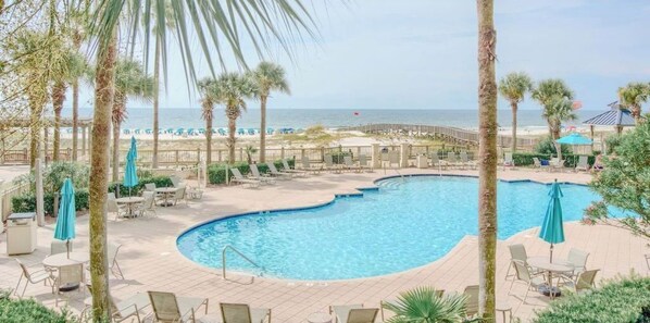 Relax by the pool surrounded by palm trees and enjoy stunning ocean views.