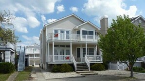 A two-story house with a balcony and a front porch.