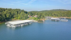 A large floating structure with multiple docks and a covered area, surrounded by a forested shoreline. - Carters Lake, Lakeside Cabin #9, includes free boat slip at the Marina (Ellijay)