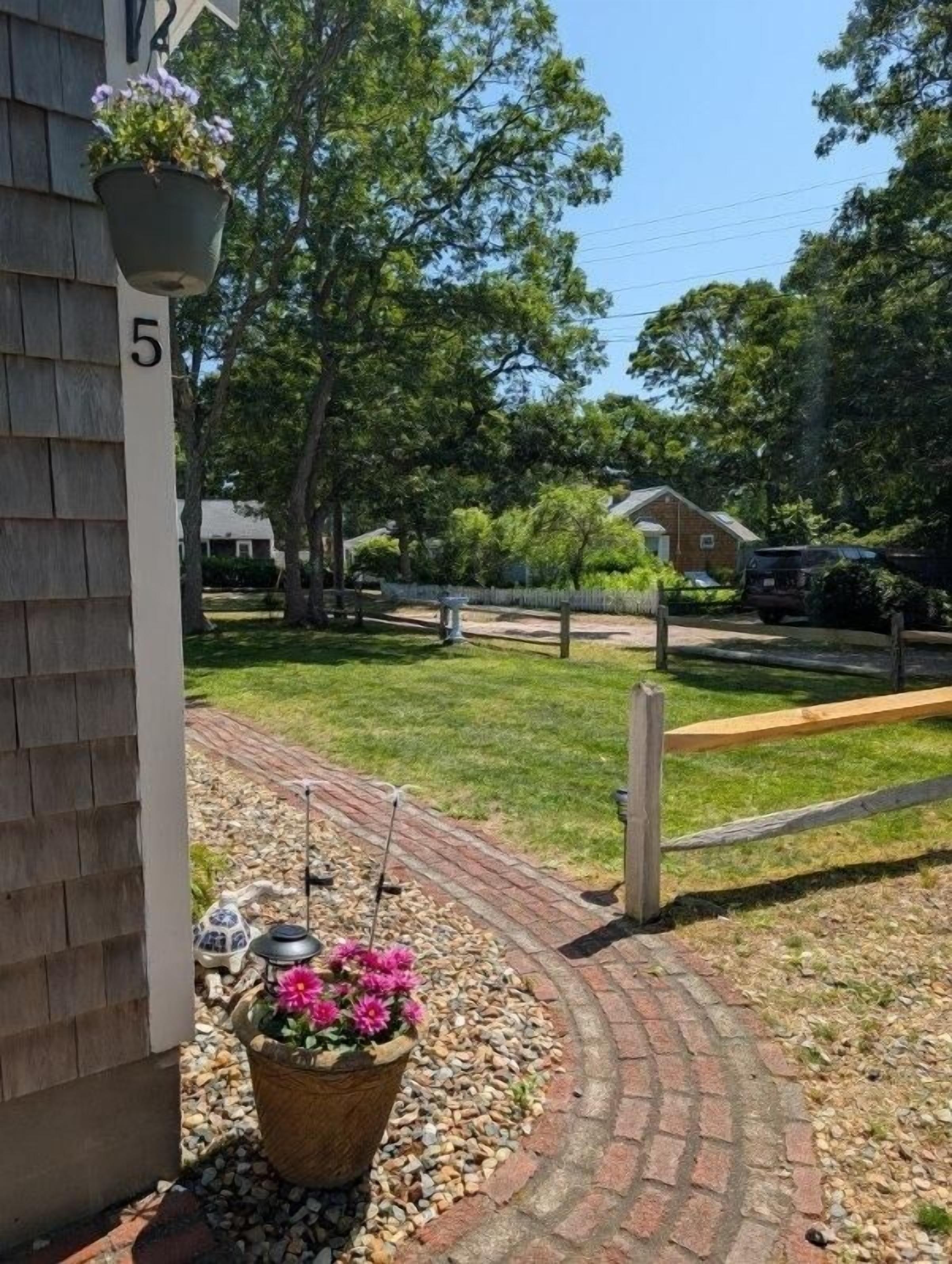A residential area with a paved driveway leading to a house marked with the number 5.