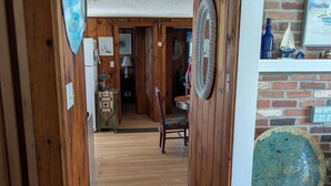 Un pasillo de madera con un comedor al fondo.