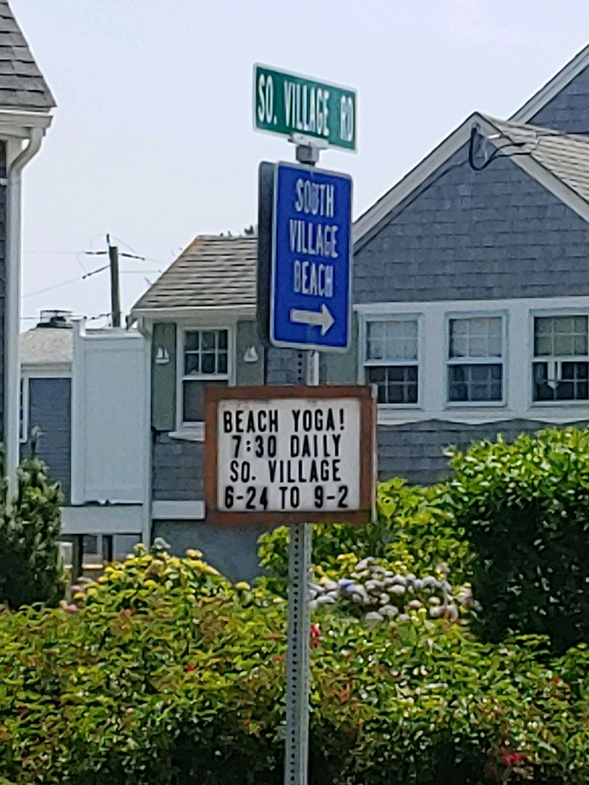A street sign for South Village Beach with a yoga class schedule.