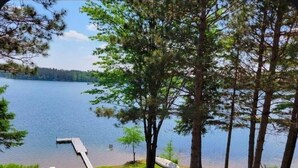 A lakeside view with a dock, trees, and a grassy area. - Bony Lake North in Barnes, WI on Bony Lake with great access to AVT & Snowmobile Trails (Barnes)