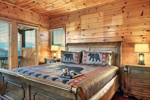 Un dormitorio tipo cabaña de madera con una cama, dos mesitas de noche y un aparador.