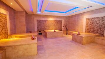 Relax in a serene spa area with a central seating area, wooden bench, and mosaic-adorned walls.