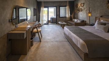 Una habitación de hotel moderna con una cama grande, un escritorio con silla, una mesita pequeña y un espejo amplio.