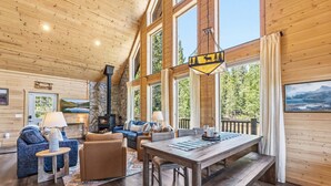 A cabin interior with a fireplace, seating area, and a view of the outdoors. - Custom Craftsman Chalet🏡Fenced Yard for Pets🍃Aspens, Hot Tub 💰$0 Cleaning & Pet Fee (Fairplay)
