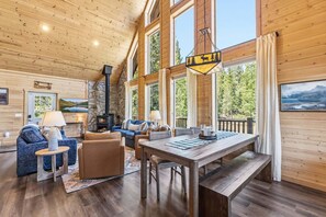A cabin interior with a fireplace, seating area, and a view of the outdoors. - Custom Craftsman Chalet🏡Fenced Yard for Pets🍃Aspens, Hot Tub 💰$0 Cleaning & Pet Fee (Fairplay)