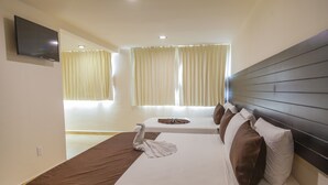 A hotel room with a large bed, a TV mounted on the wall, and a window with curtains. - Mayev Express (Santa María Huatulco)