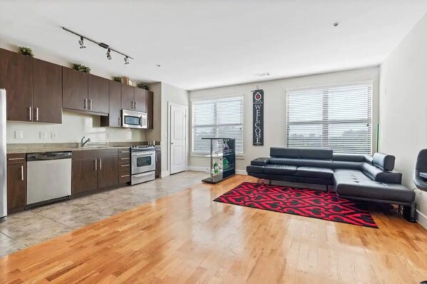 Enjoy a spacious living area with a kitchen and seating space, featuring a sofa and microwave.