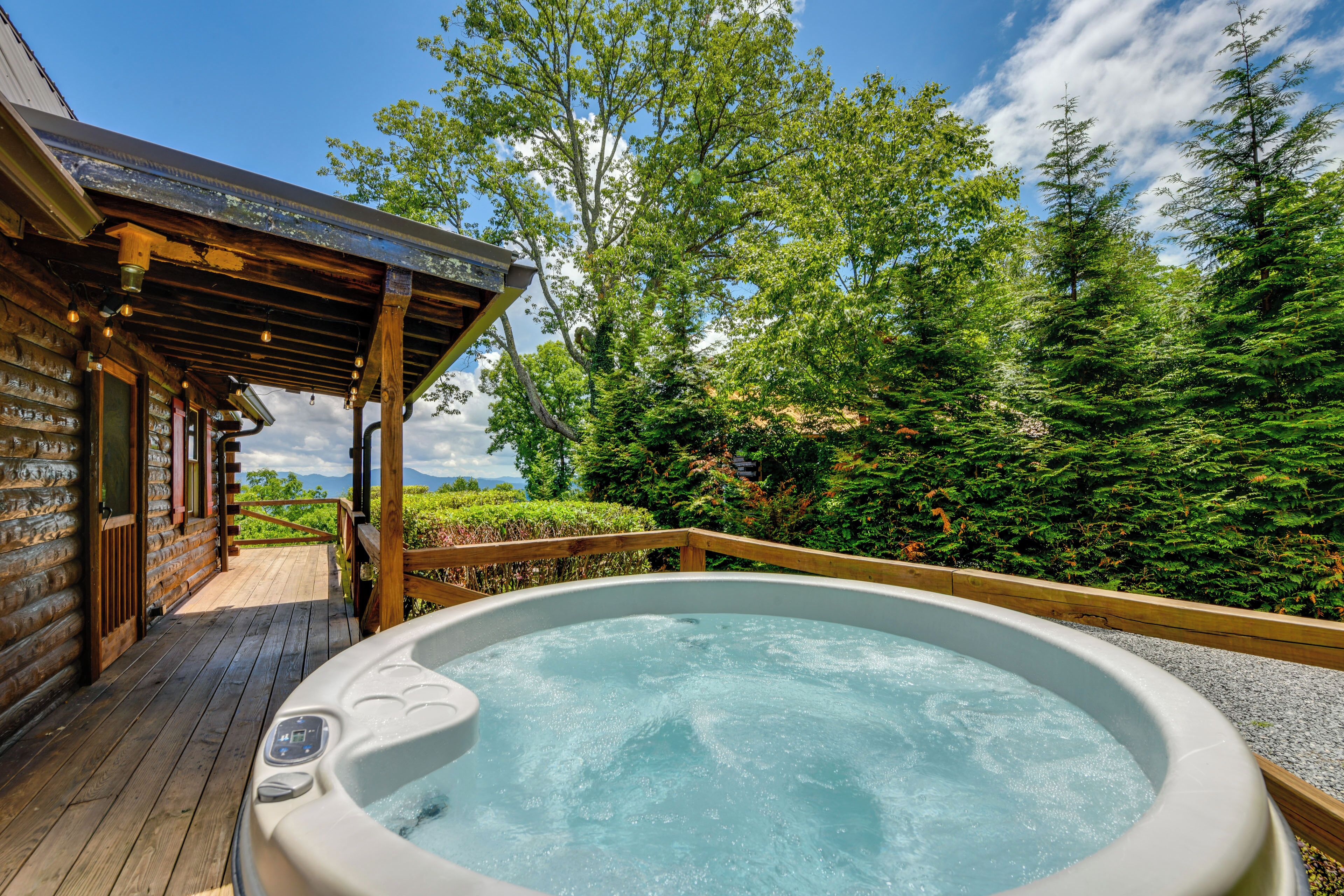 A hot tub on a wooden deck with a wooden pergola overhead.
