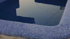 A rooftop pool area with blue tiled seating and a view of surrounding buildings. - Royal Garden Hotel Beirut (Beirut)