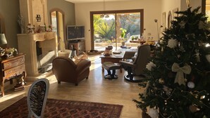 Una sala de estar amplia con chimenea, televisor y árbol de Navidad.