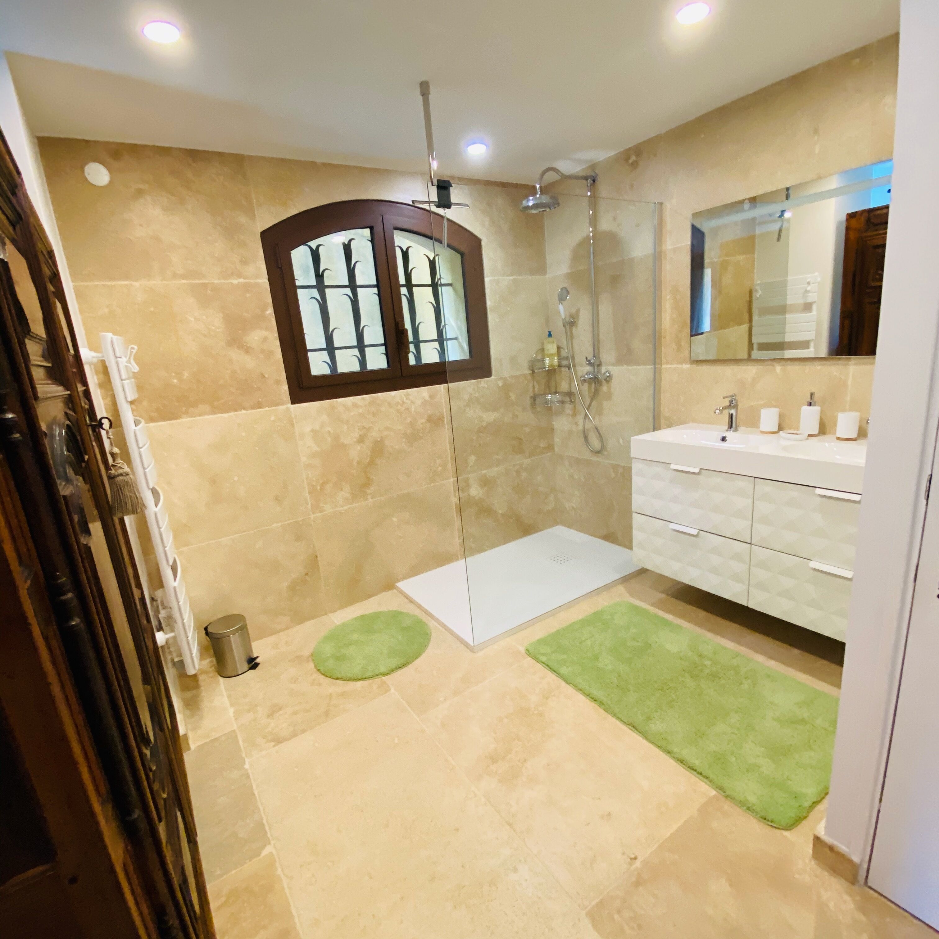 A modern bathroom with a shower, a bathtub, and a vanity with a mirror.