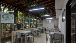 A restaurant with outdoor seating, a sign indicating it is a hotel restaurant, and a view of the street outside. - Hotel Med Colombia (Medellín)