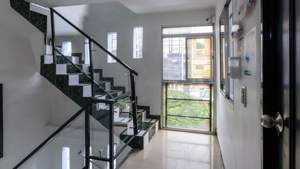 A modern staircase with glass railings leading to a landing. - Hotel Med Colombia (Medellín)