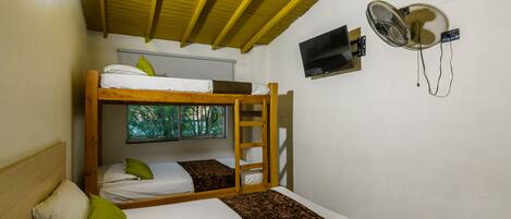 Habitación con literas, televisión y ventilador de techo.