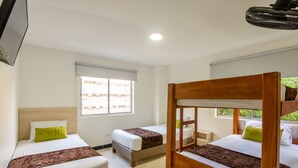 A hotel room with two single beds, a wooden headboard, and a window with a view of buildings. - Hotel Med Colombia (Medellín)