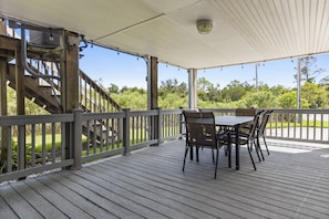 Enjoy a serene outdoor space with a deck, table, and chairs, surrounded by lush greenery and a scenic view.