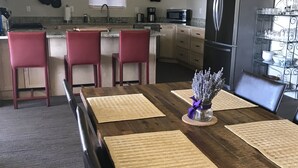 Ein Essbereich mit Holztisch, roten Stühlen und einer Küche im Hintergrund.