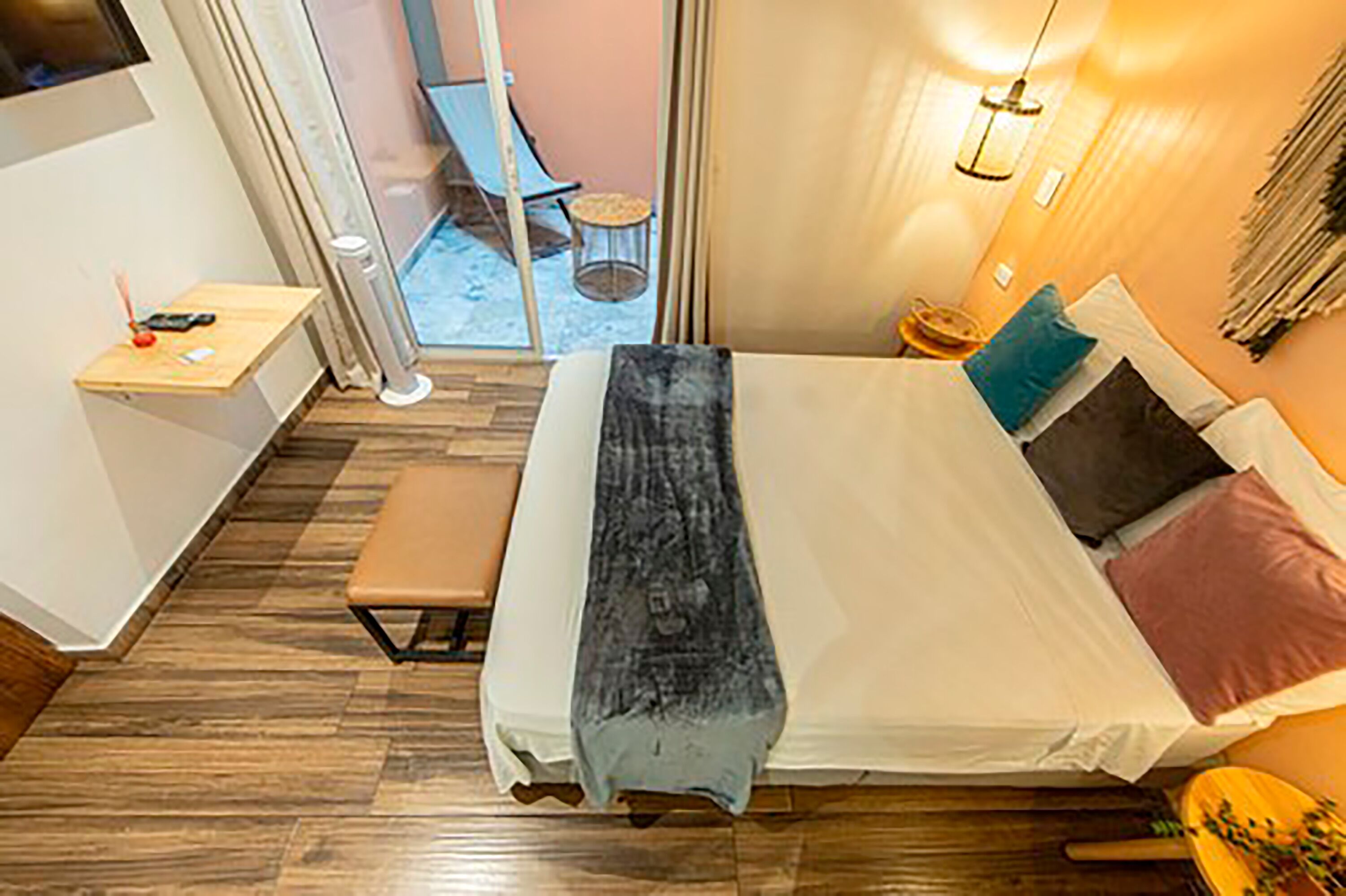 Een moderne hotelkamer met een groot bed, een klein bureau en uitzicht naar buiten.