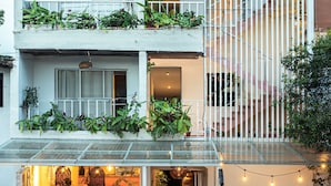 A multi-level building with balconies, outdoor seating, and string lights. - Vivus La Martina Boutique Hotel (Medellín)