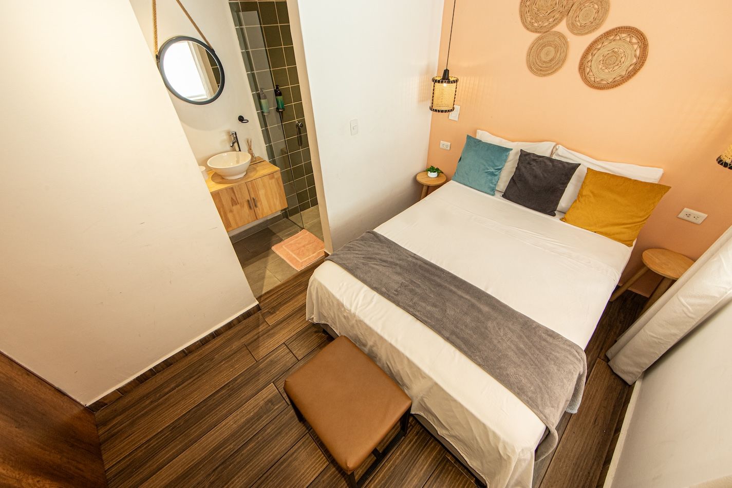 A bedroom with a bed, bedside table, and a small bench.