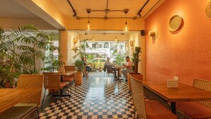 A cafe with checkered flooring, wicker furniture, and hanging pendant lights. - Vivus La Martina Boutique Hotel (Medellín)