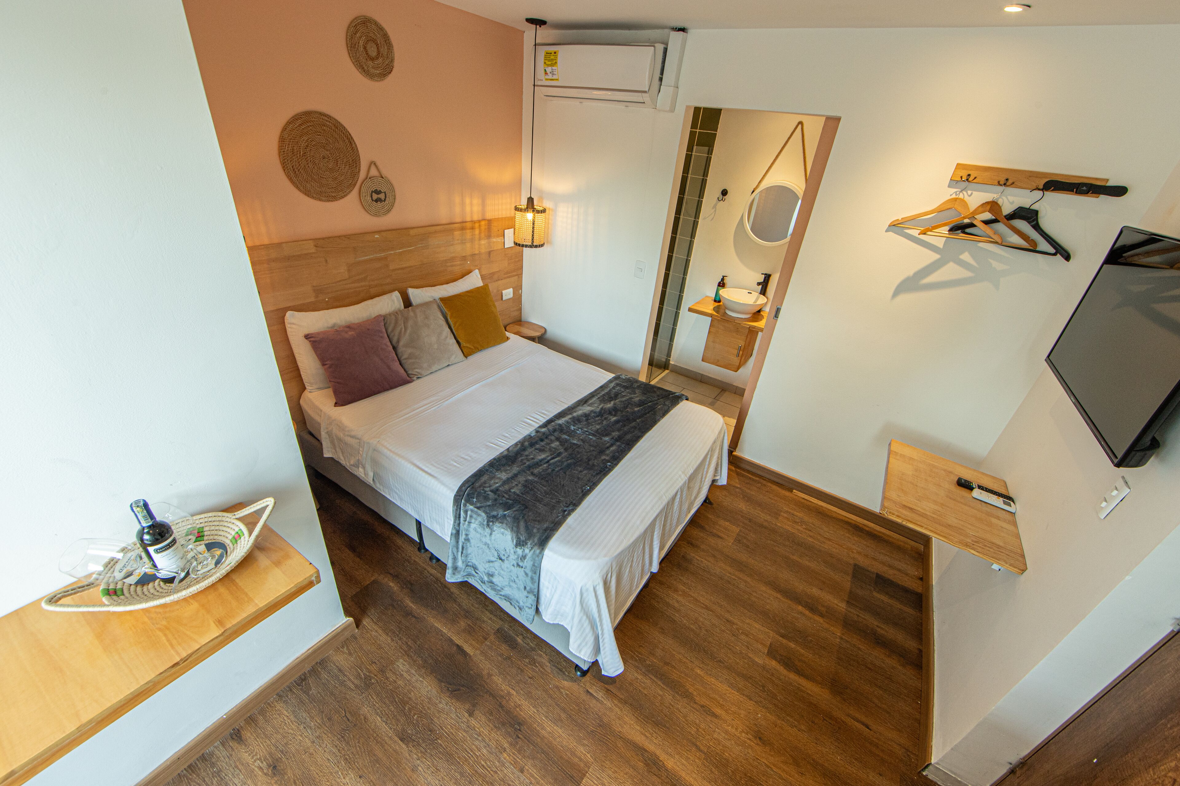 A neatly arranged bedroom with a bed, bedside table, and a mirror.