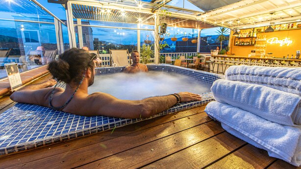 A hot tub area with a glass enclosure, a bar, and a poolside seating area. - Vivus La Martina Boutique Hotel (Medellín)