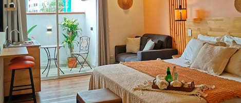 Una habitación de hotel con cama, escritorio, silla y balcón con vistas a edificios.