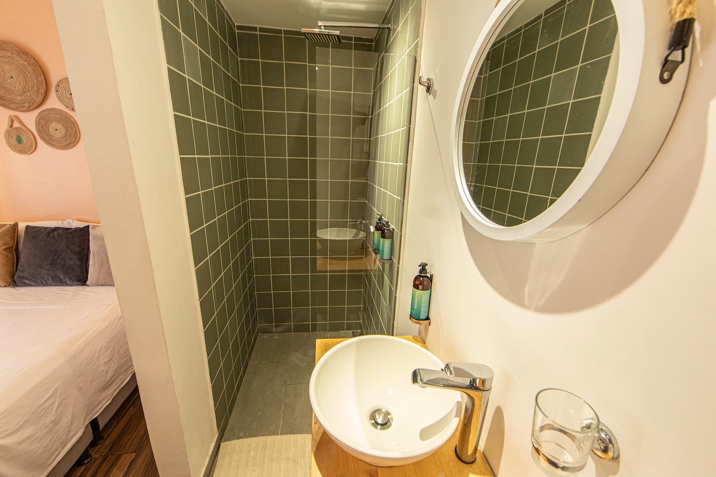 A small bathroom with a shower, a sink, and a mirror.