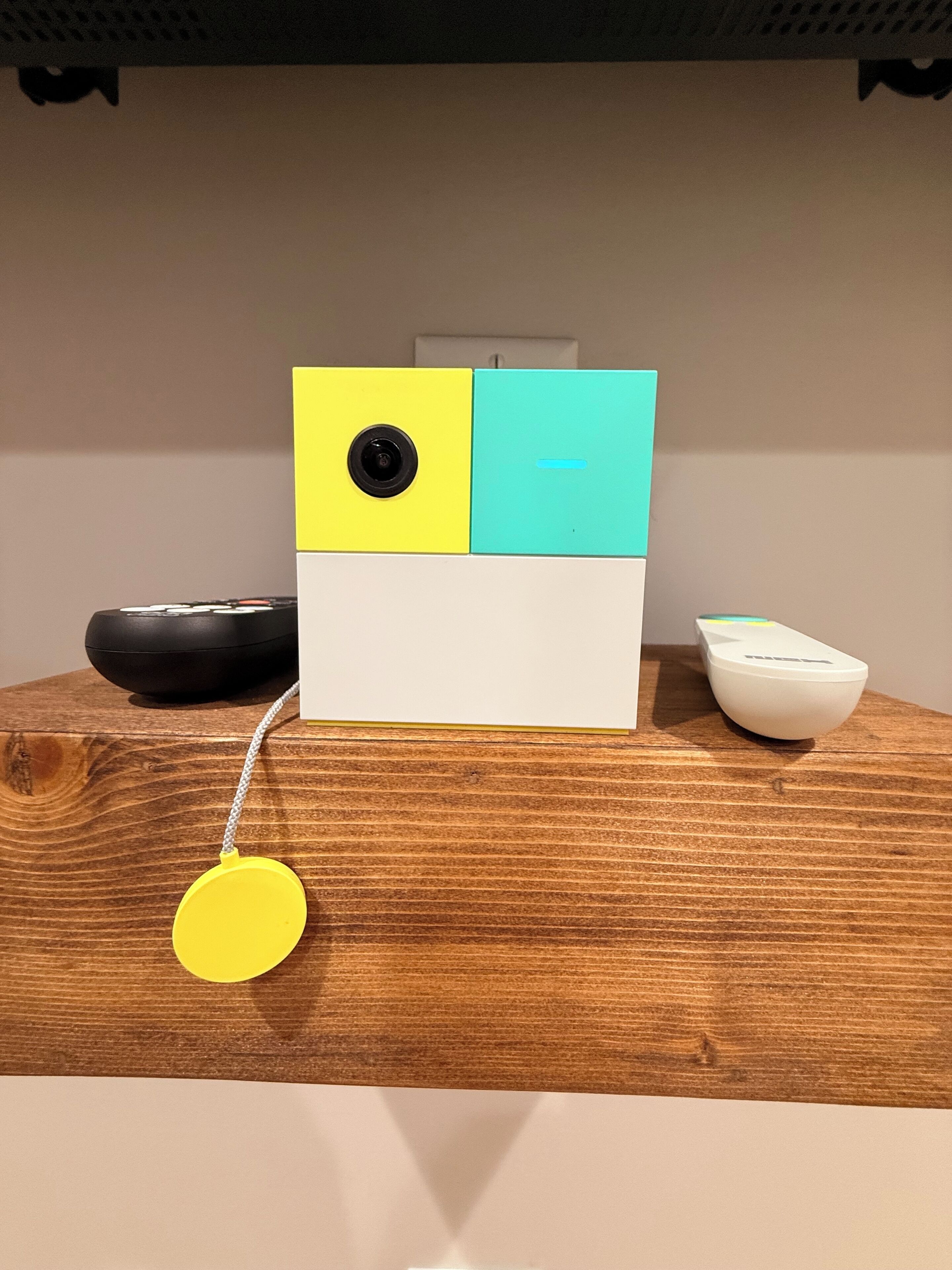 A wooden table with a white object, a black object, and a yellow object.