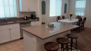 A kitchen with a central island, bar stools, a dining table with chairs, and decorative wall art. - LOWEST PRICE OF THE SEASON! 
NEW and AMAZING! Spacious! DOD, Military Welcome! (Imperial Beach)