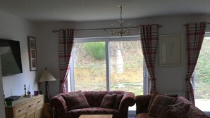 A living room with a sofa set, a coffee table, and a TV on a cabinet.