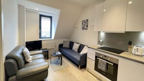 A modern apartment with a living area, kitchenette, and a window providing natural light. - Remarkable 1-Bed Apartment in Slough (Slough)