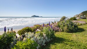 Un paysage côtier avec une plage, des vagues et une île au loin.