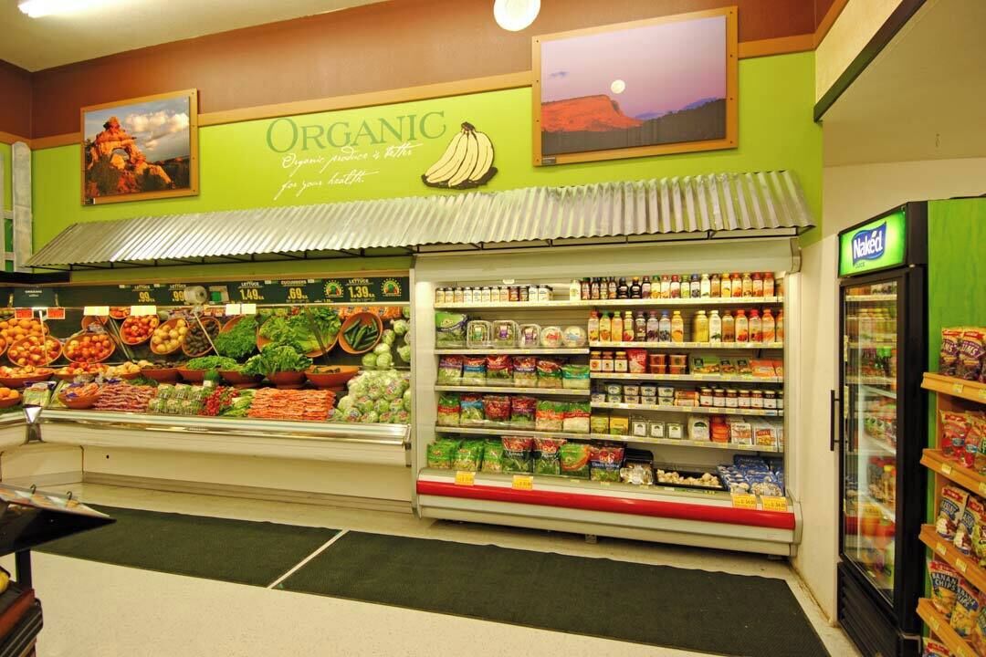 A grocery store with an organic section, fresh produce, and a refrigerated display.
