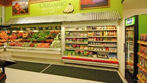 A grocery store with an organic section, fresh produce, and a refrigerated display.