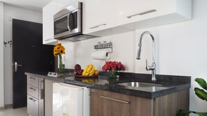 A modern kitchen with a built-in microwave, a stainless steel sink, and a refrigerator. - Loft Sinaloa By The Local Way (Mexico City)