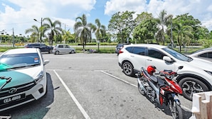 Un estacionamiento con varios coches y una motocicleta.