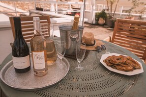 A table set with wine bottles, glasses, a metal bucket, and a plate of food. - Large charming apartment in the heart of Nîmes with spectacular rooftop, garage (Nîmes)